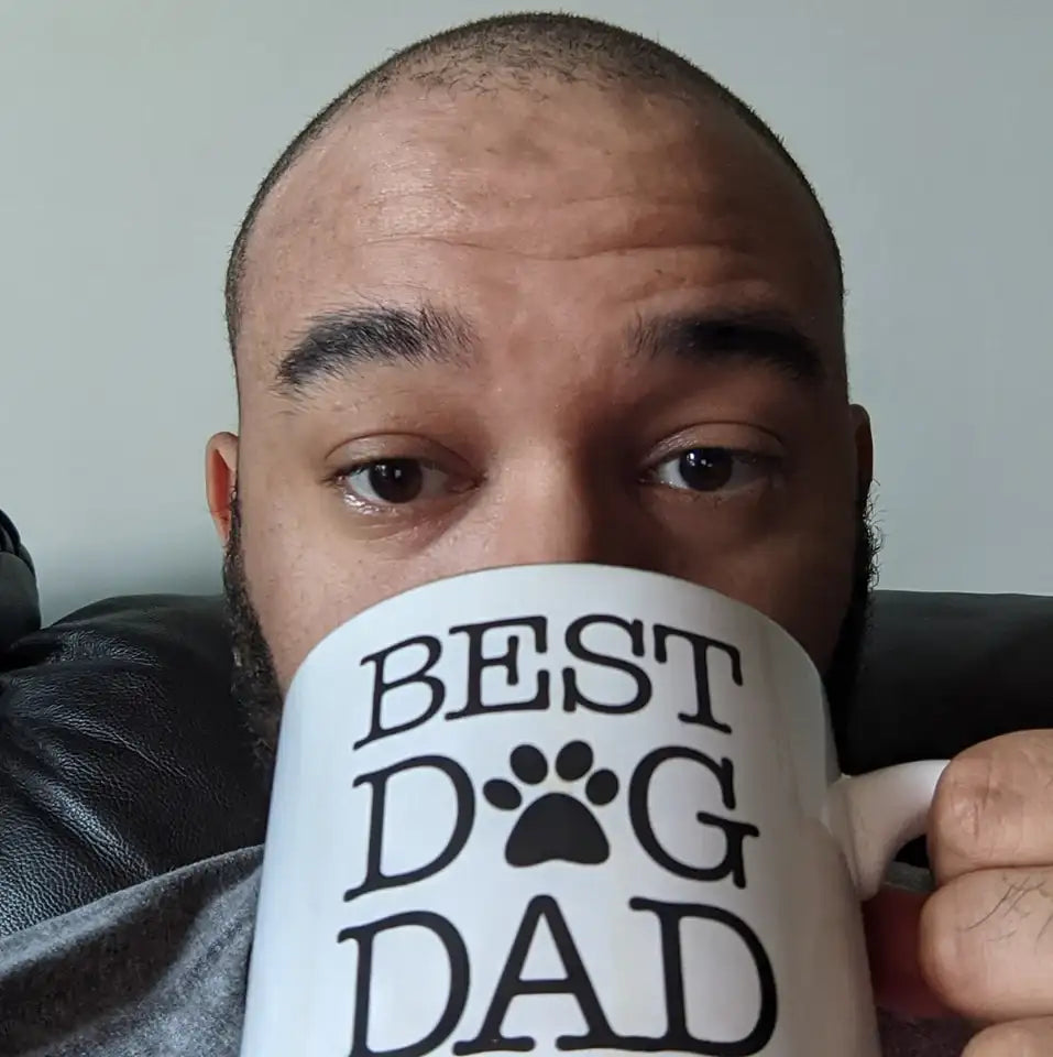 White ceramic mug with black ’best dog dad’ text and paw print design